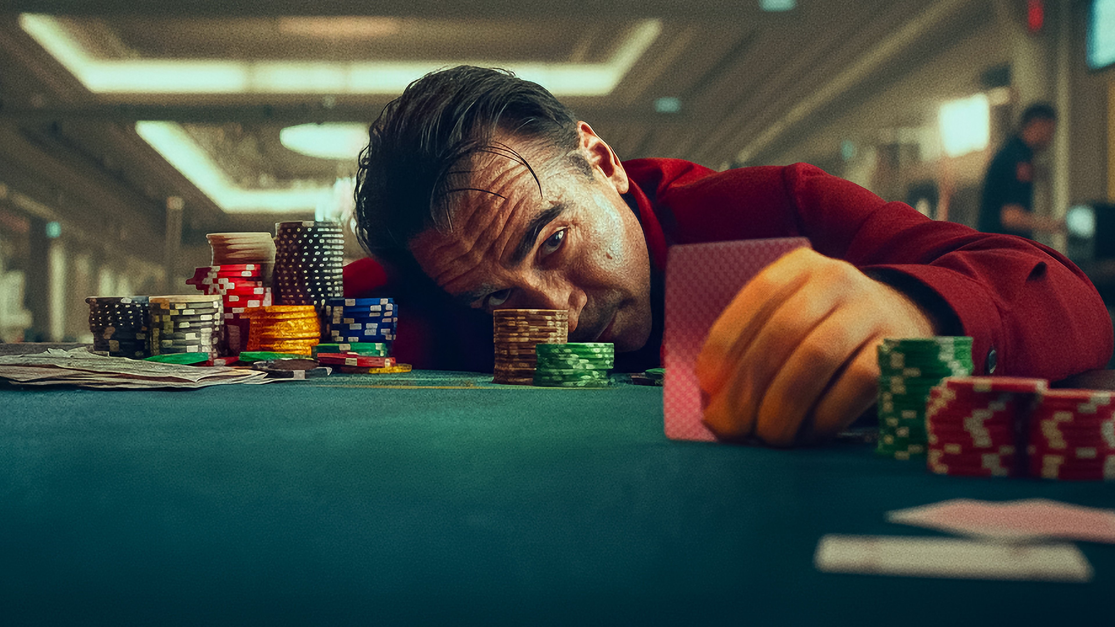 Caption: a man leaning over a table with stacks of poker chips