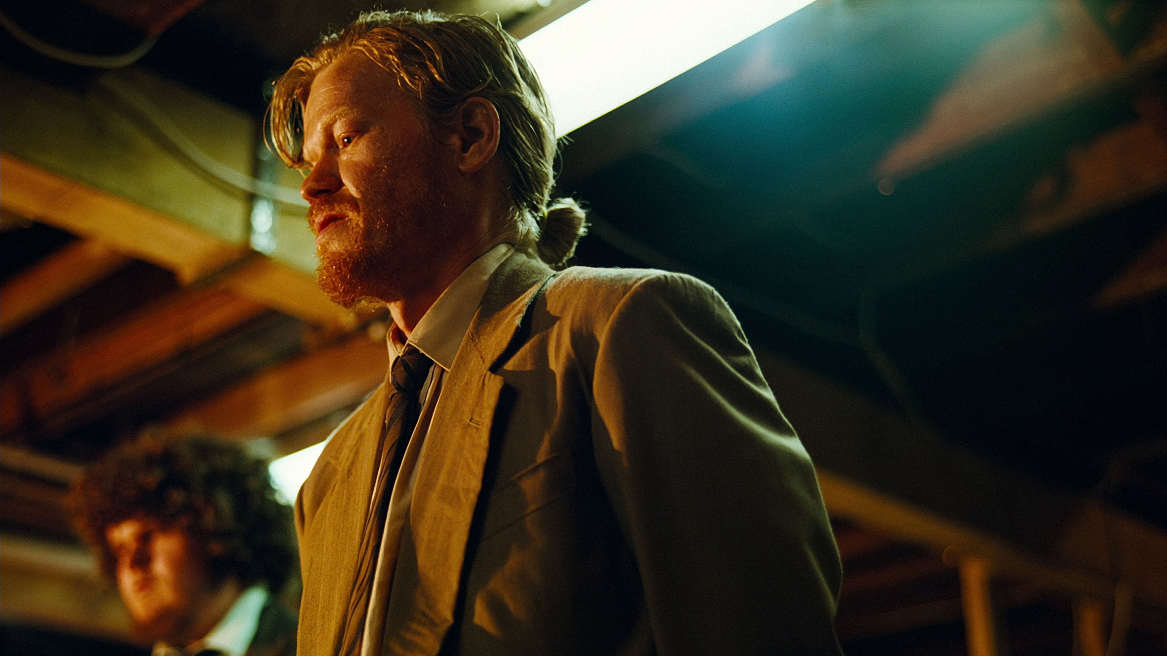 Caption: a man in a suit and tie standing in a room