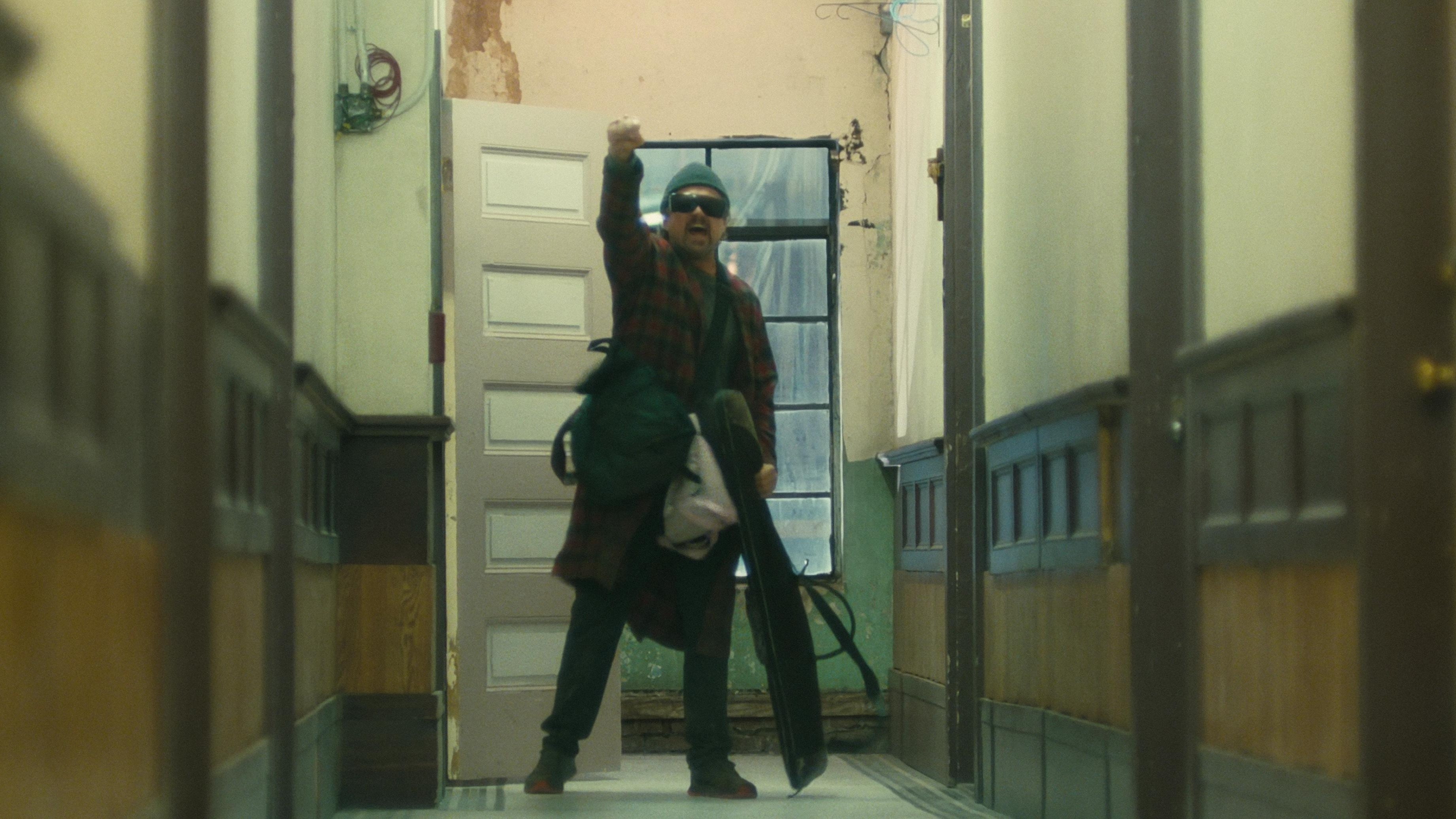 Caption: a man is walking down a hallway with a suitcase