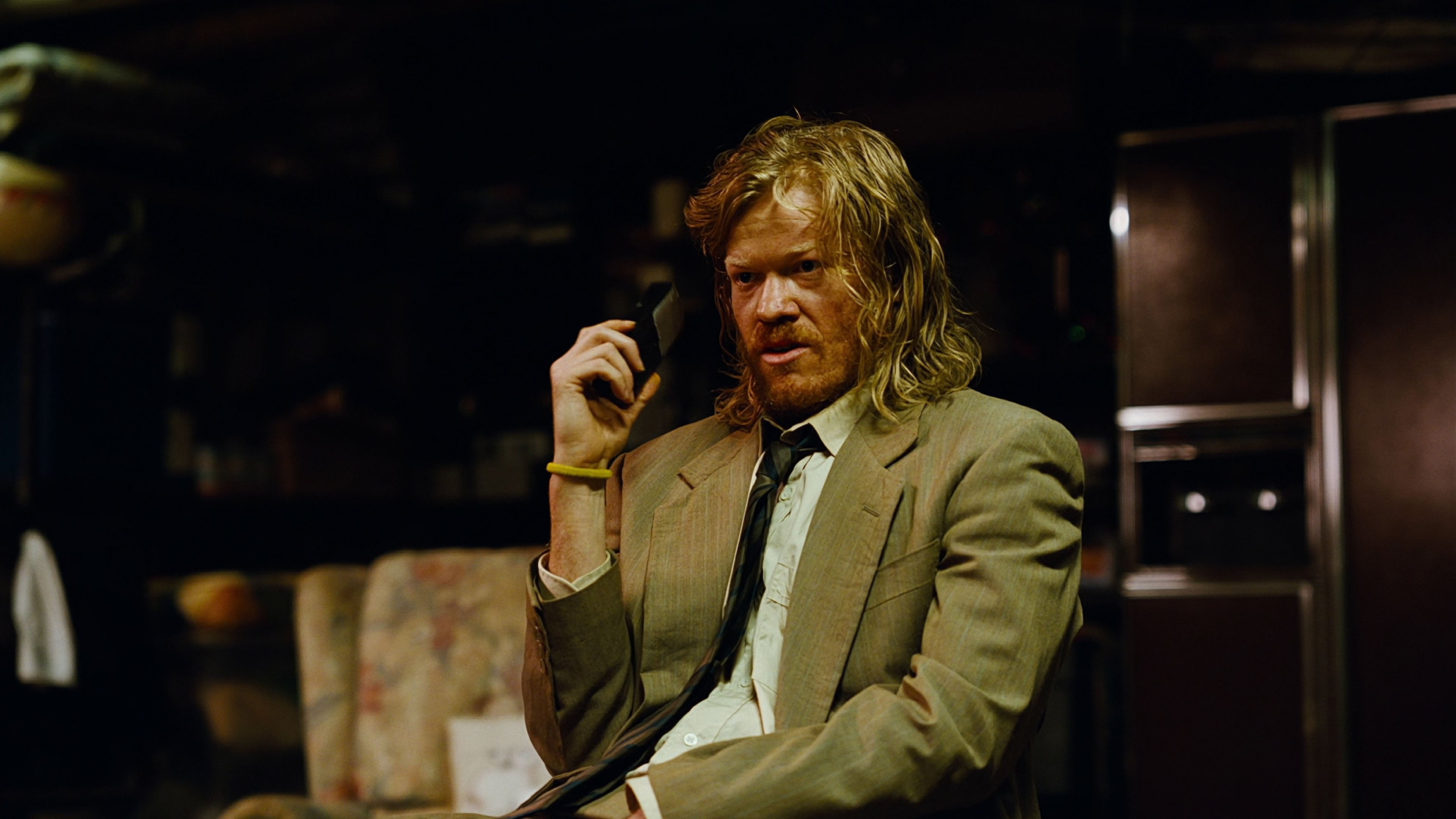 Caption: a man in a suit talking on a cell phone