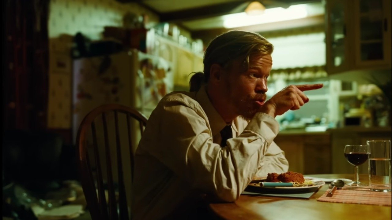 Caption: a man sitting at a table with a plate of food