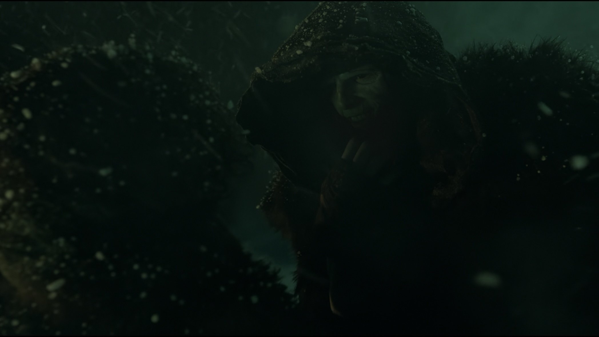 Caption: a man in a hooded jacket standing in the snow