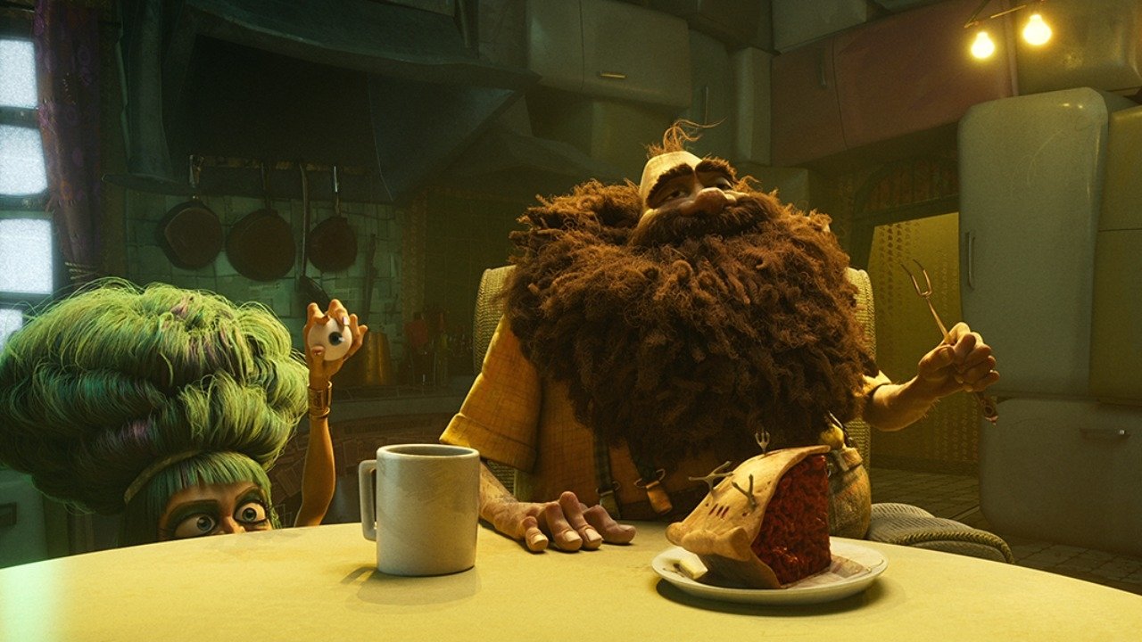 Caption: a man with a beard sitting at a table in front of a plate of food