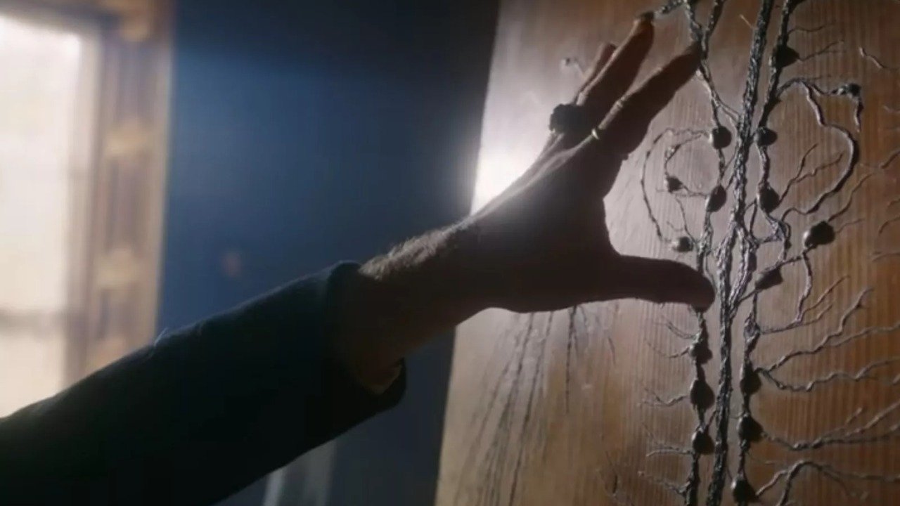 Caption: a person's hand reaching for something on a wall