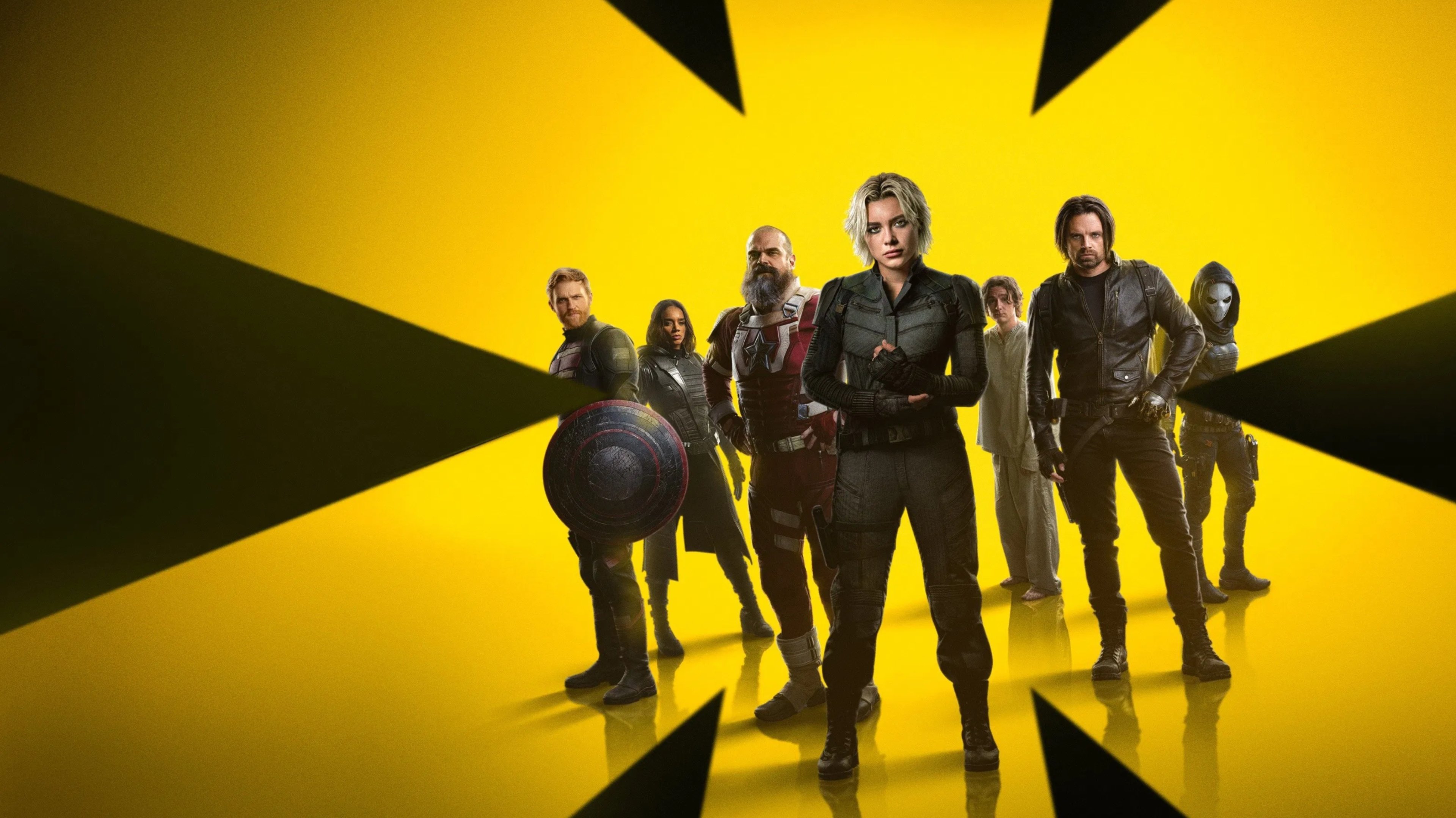 Caption: a group of people standing in front of a yellow background