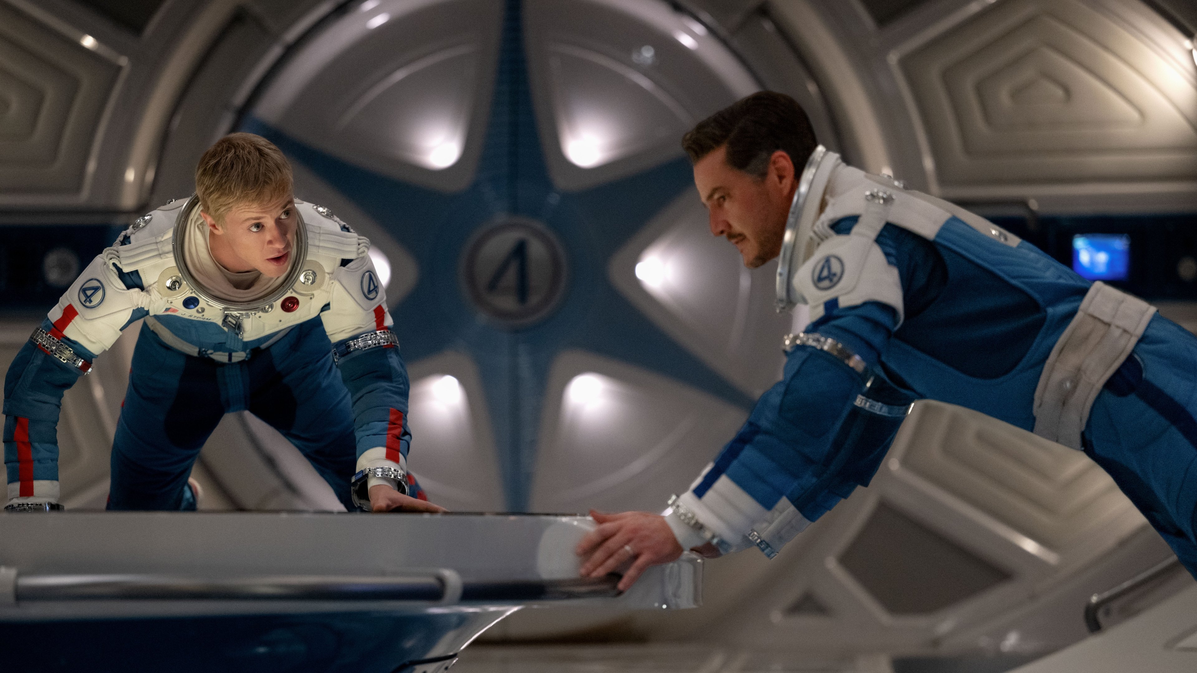 Caption: a man and a boy are in a space station