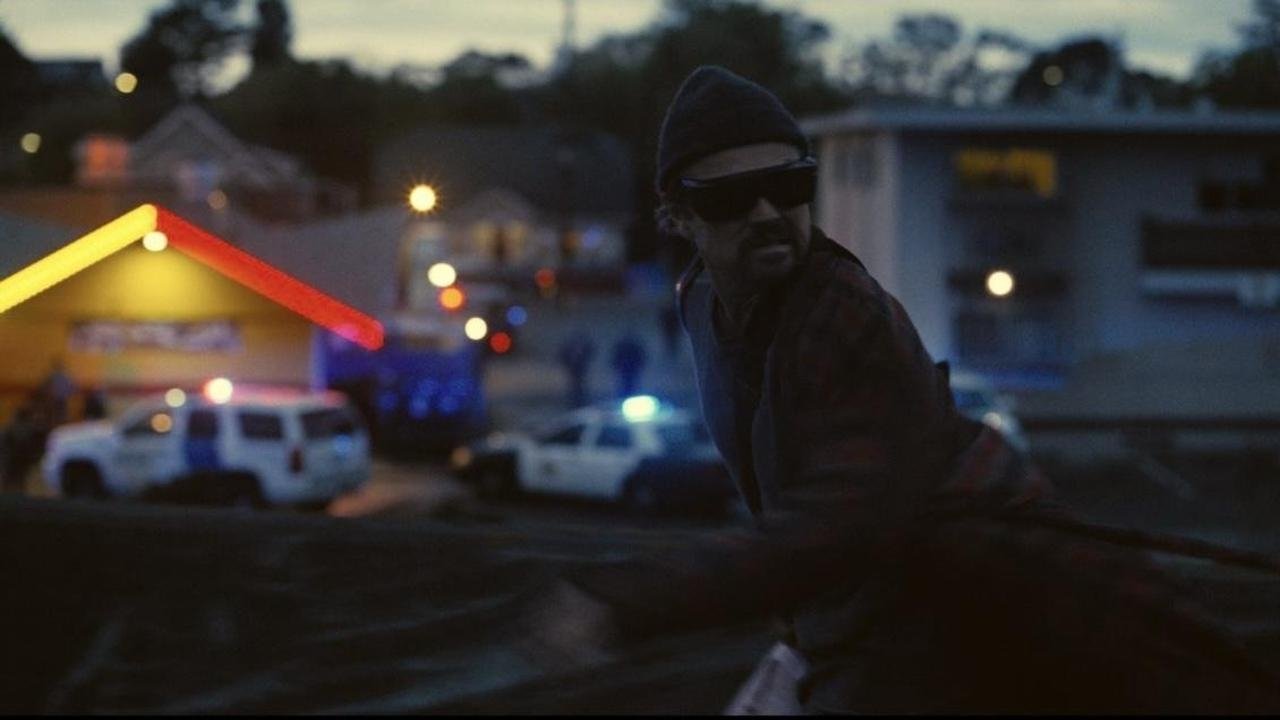 Caption: a man riding a horse down a street at night