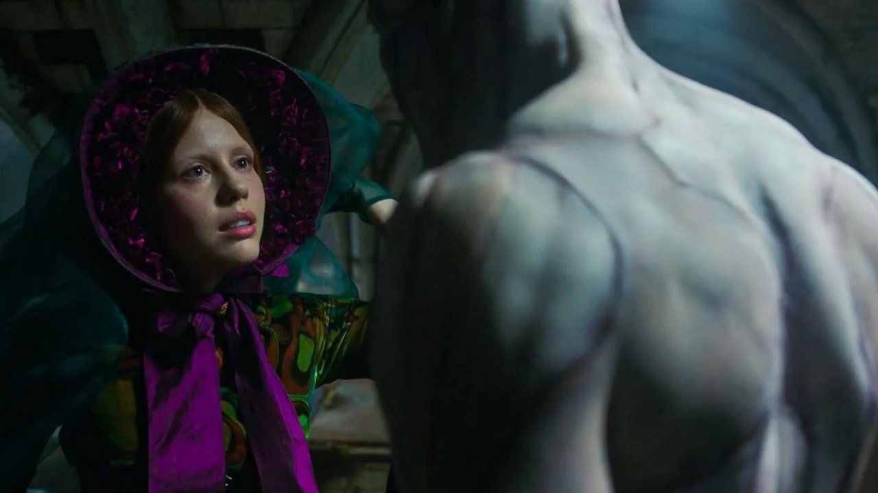 Caption: a woman in a purple dress and hat next to a statue