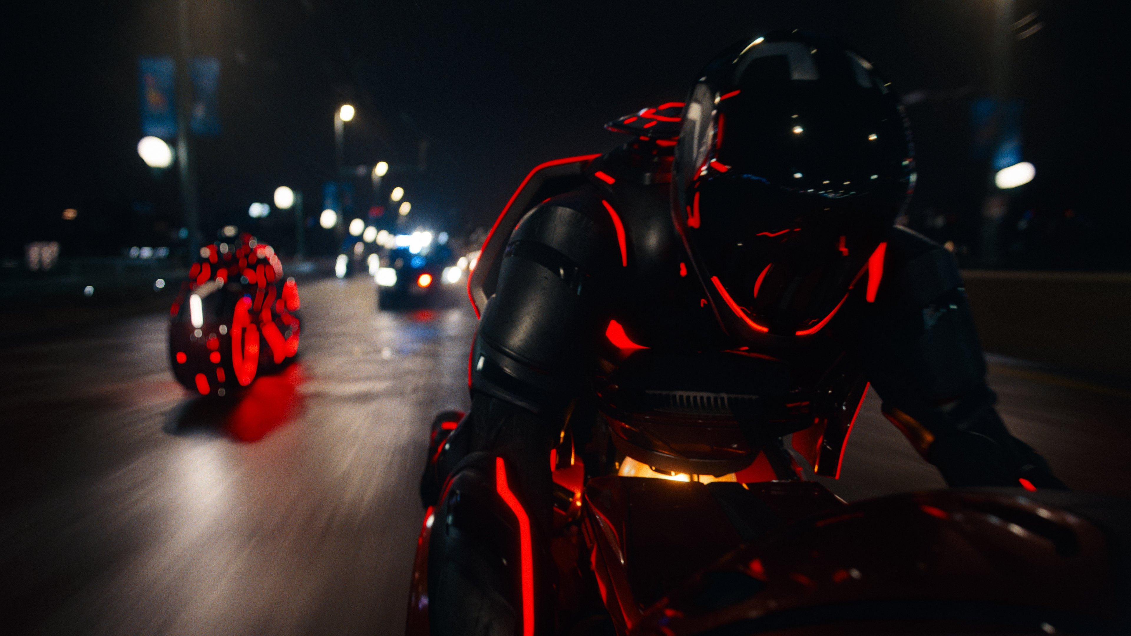 Caption: a man riding a motorcycle down a street at night