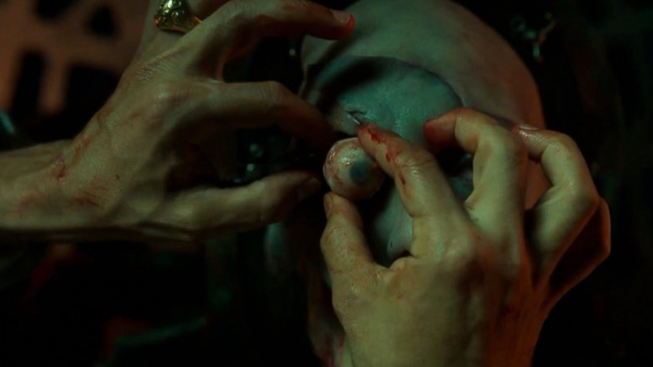 Caption: two hands holding a green object in a dark room