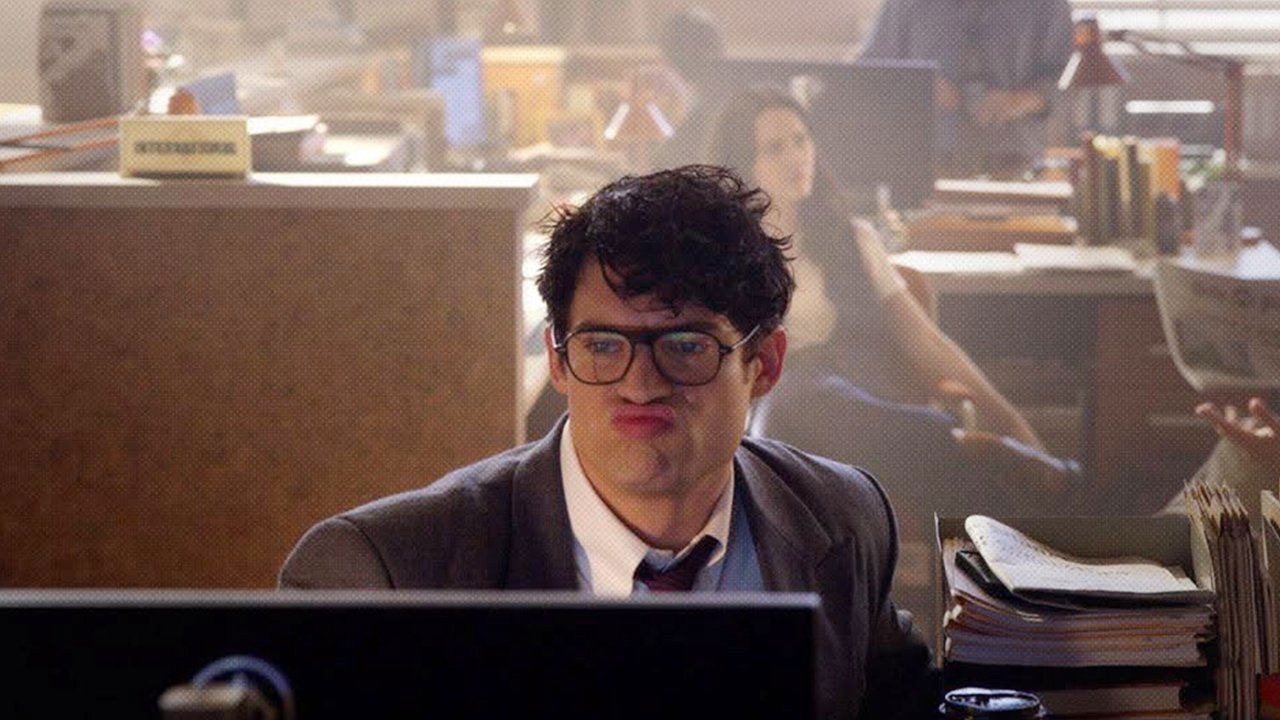 Caption: a man sitting at a desk in front of a computer