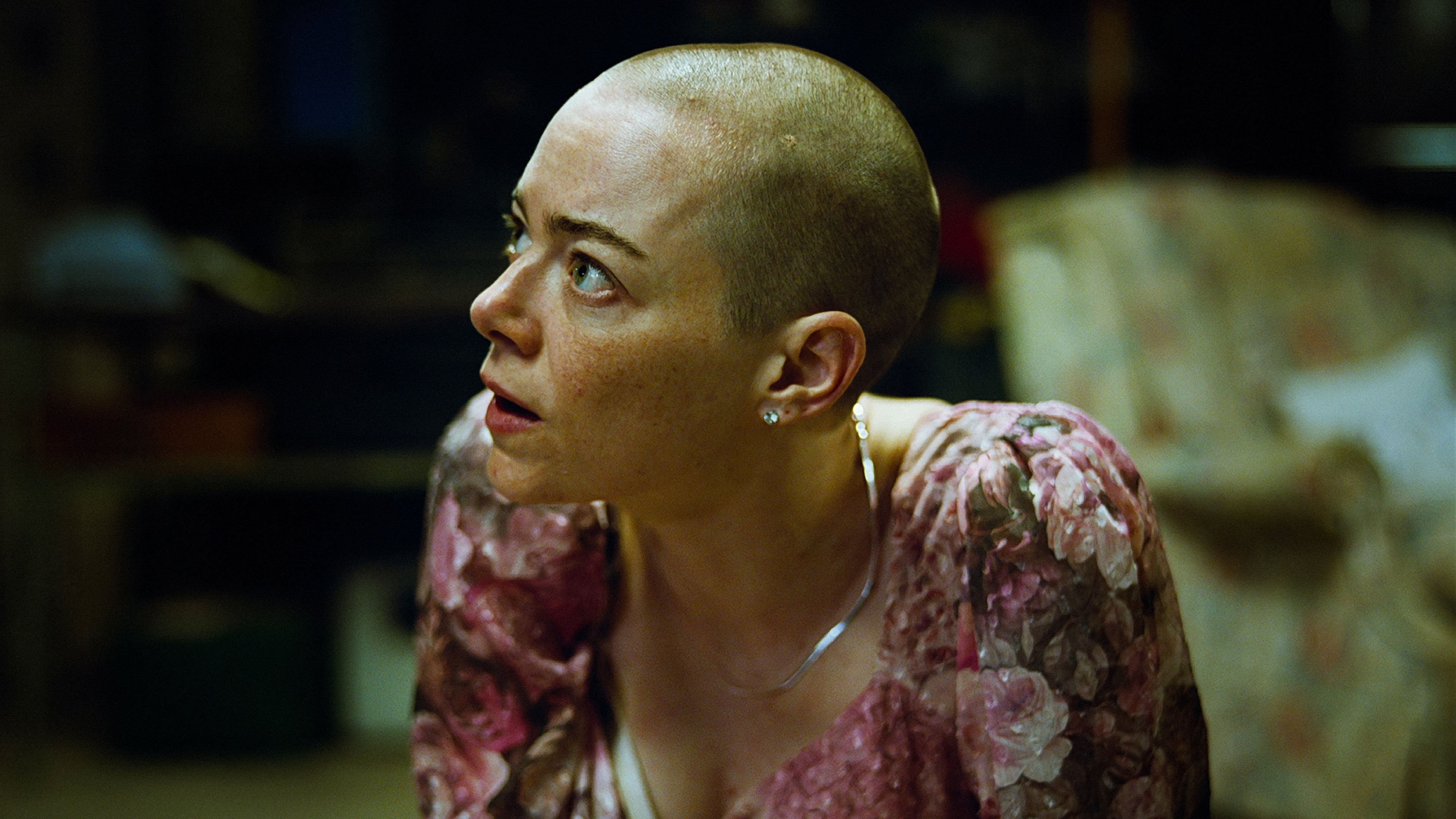 Caption: a woman with a bald head sitting on a couch