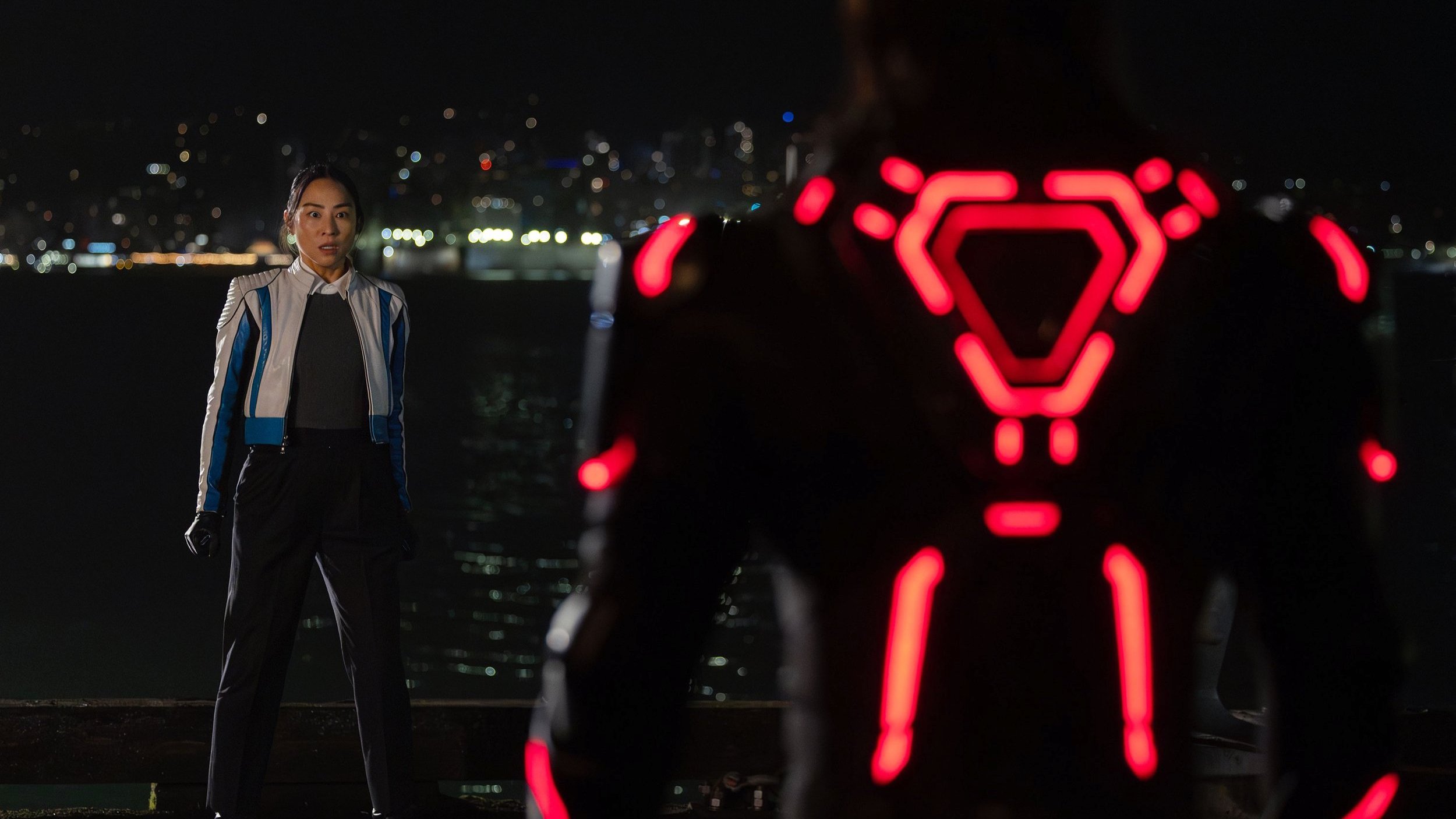 Caption: a man standing in front of a red light