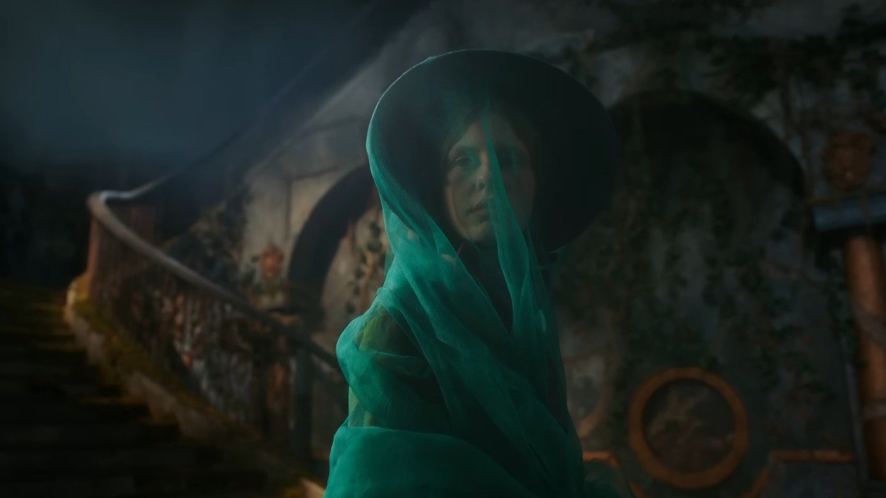 Caption: a woman in a green dress and a black hat