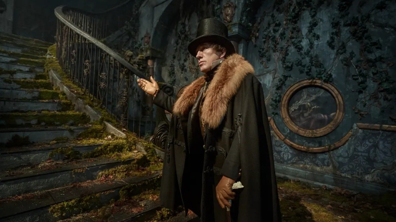 Caption: a man in a hat and coat standing in front of a staircase