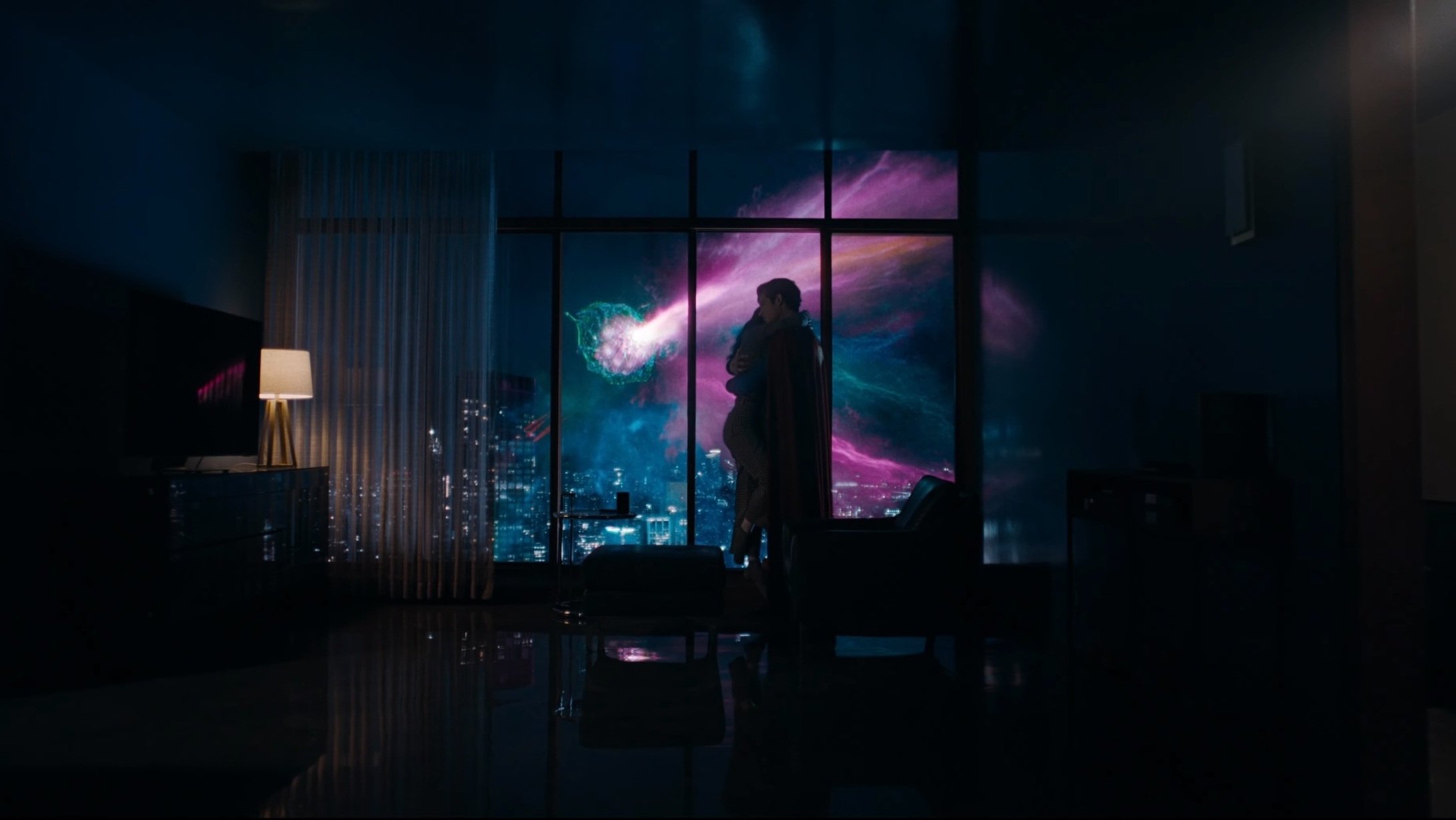Caption: a man standing in front of a window in a dark room