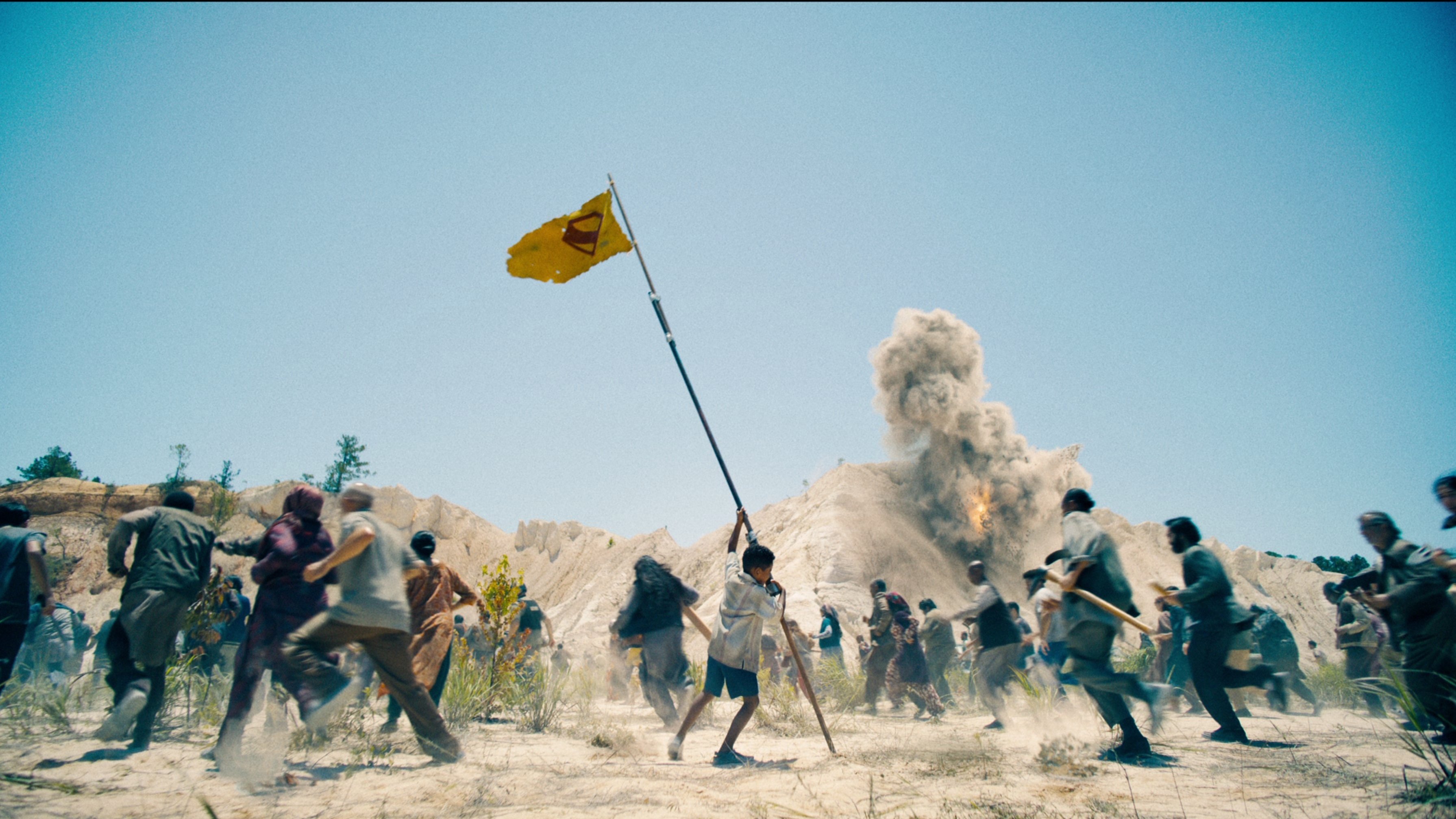 Caption: a group of people standing around a yellow flag
