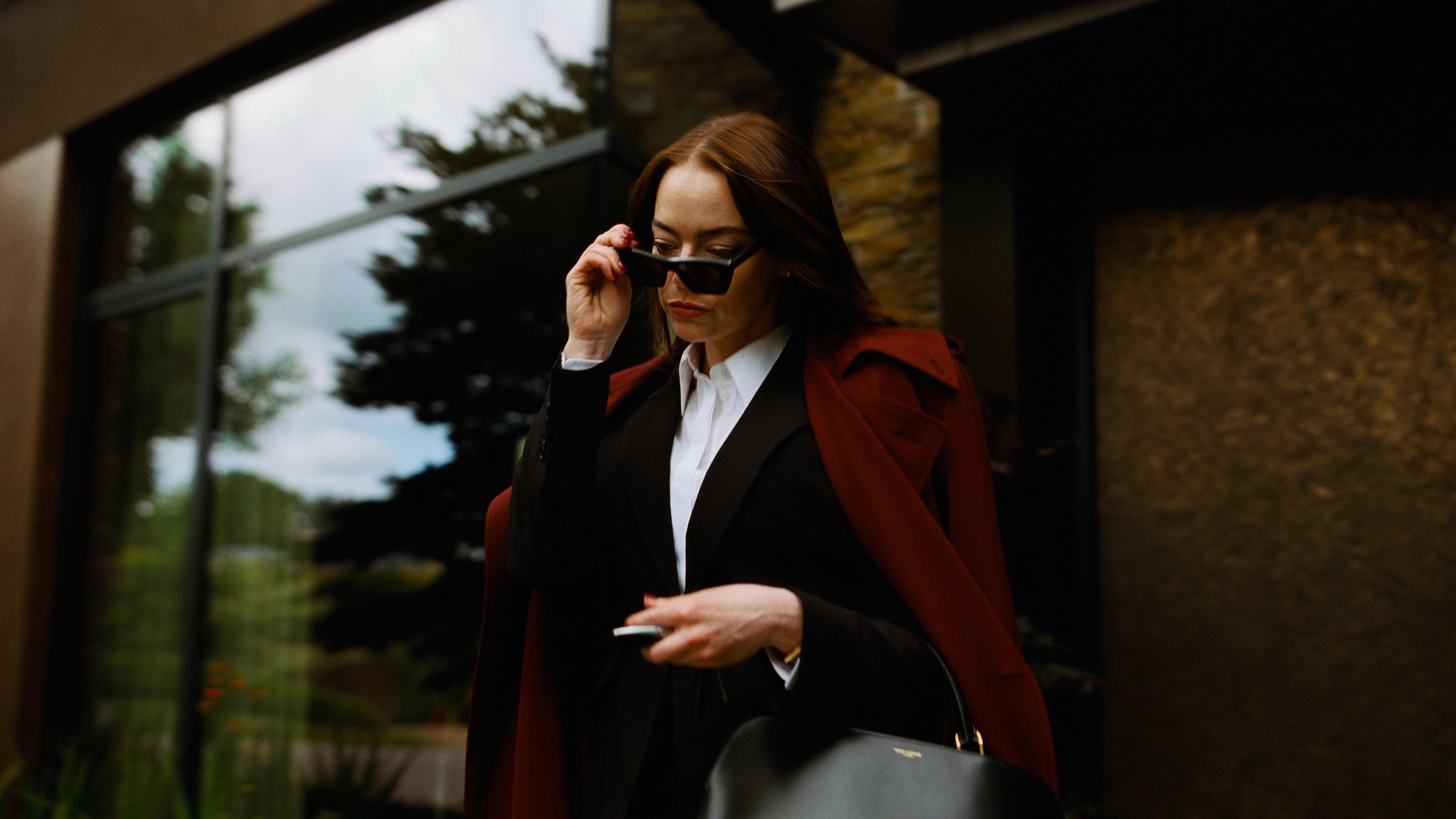 Caption: a woman talking on a cell phone while holding a purse