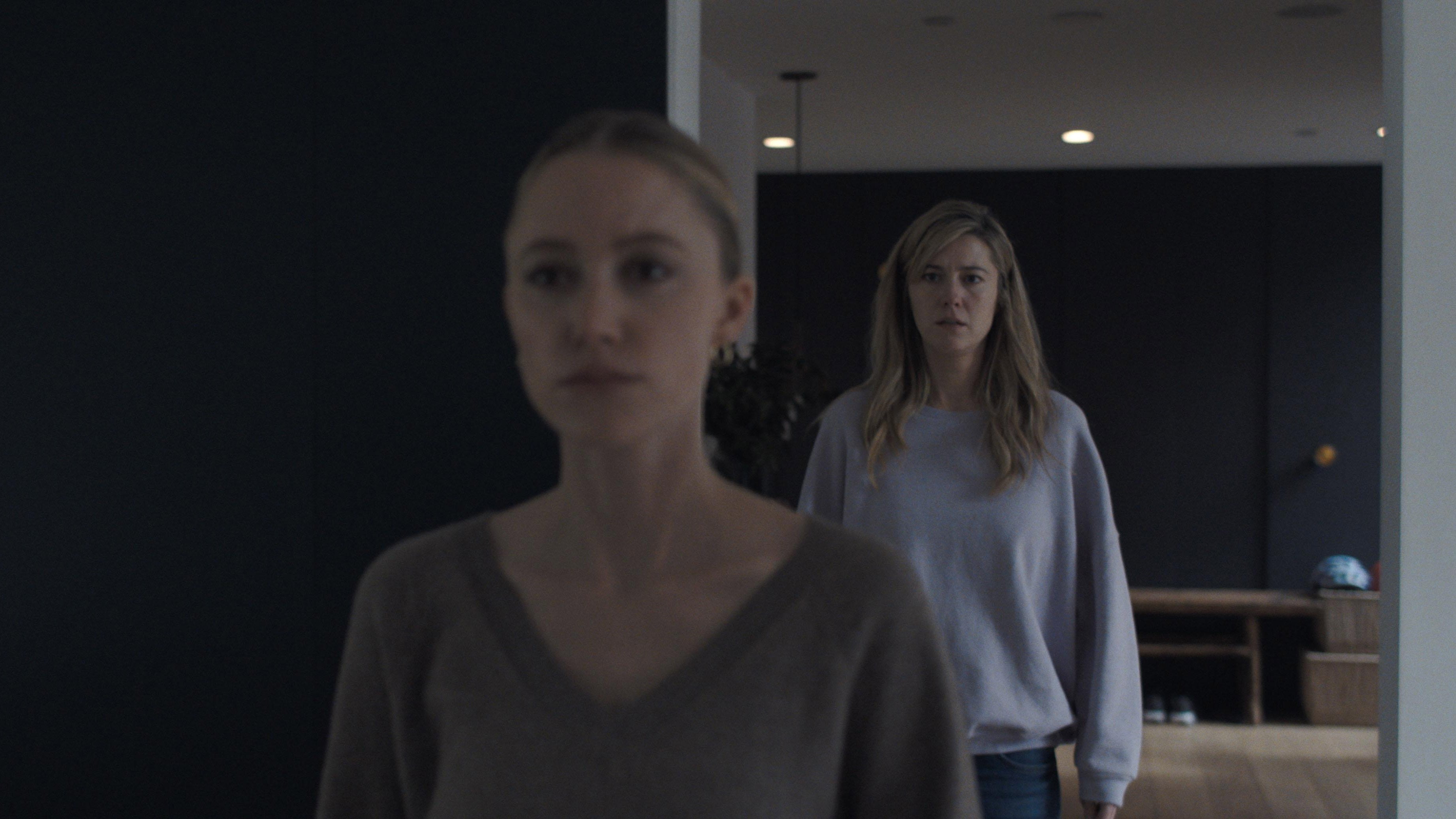 Caption: a woman standing next to another woman in a room