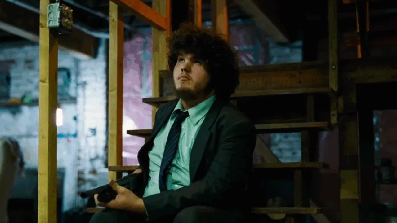 Caption: a man in a suit and tie sitting on a chair