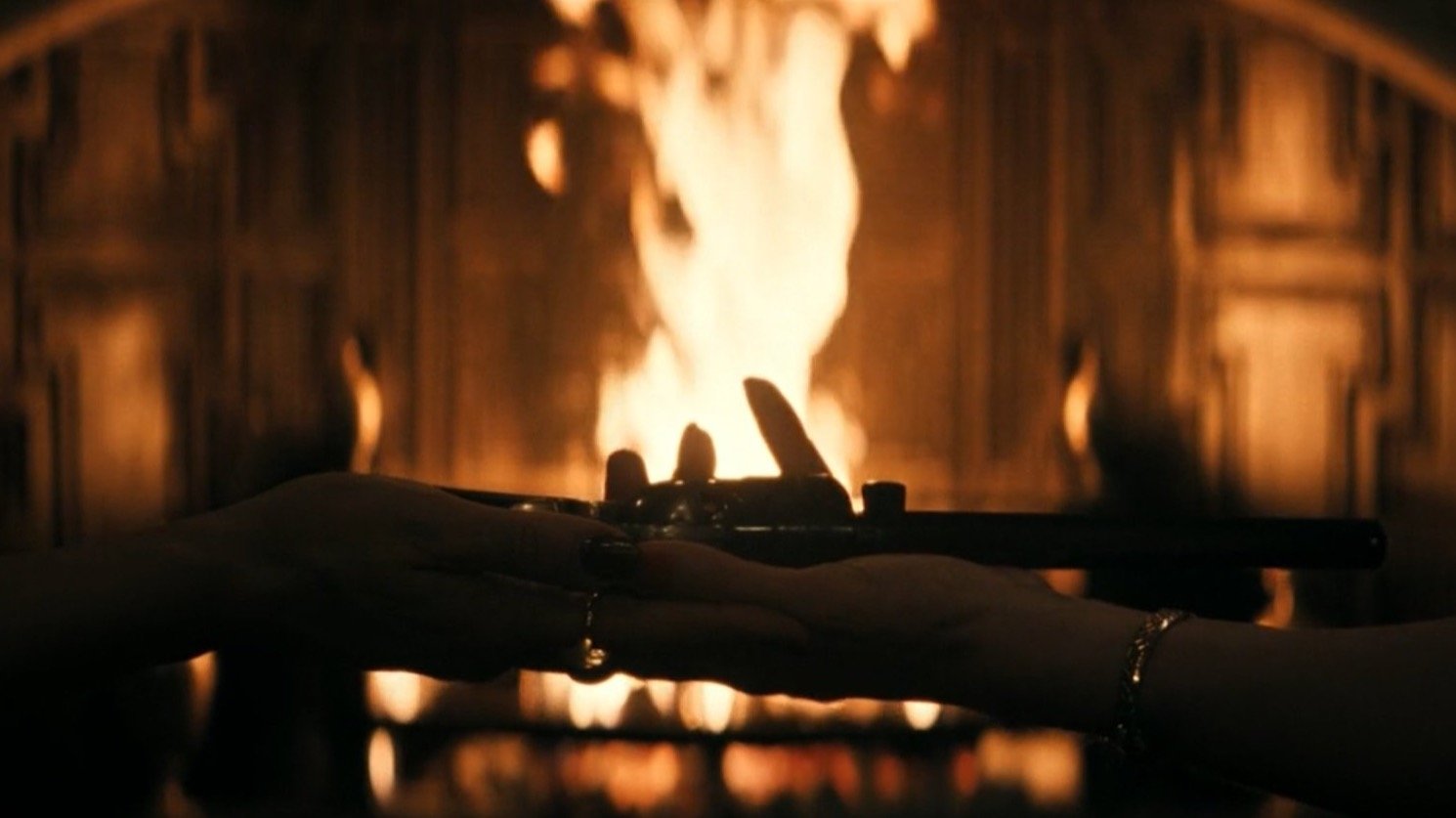 Caption: a person holding a candle in front of a fire