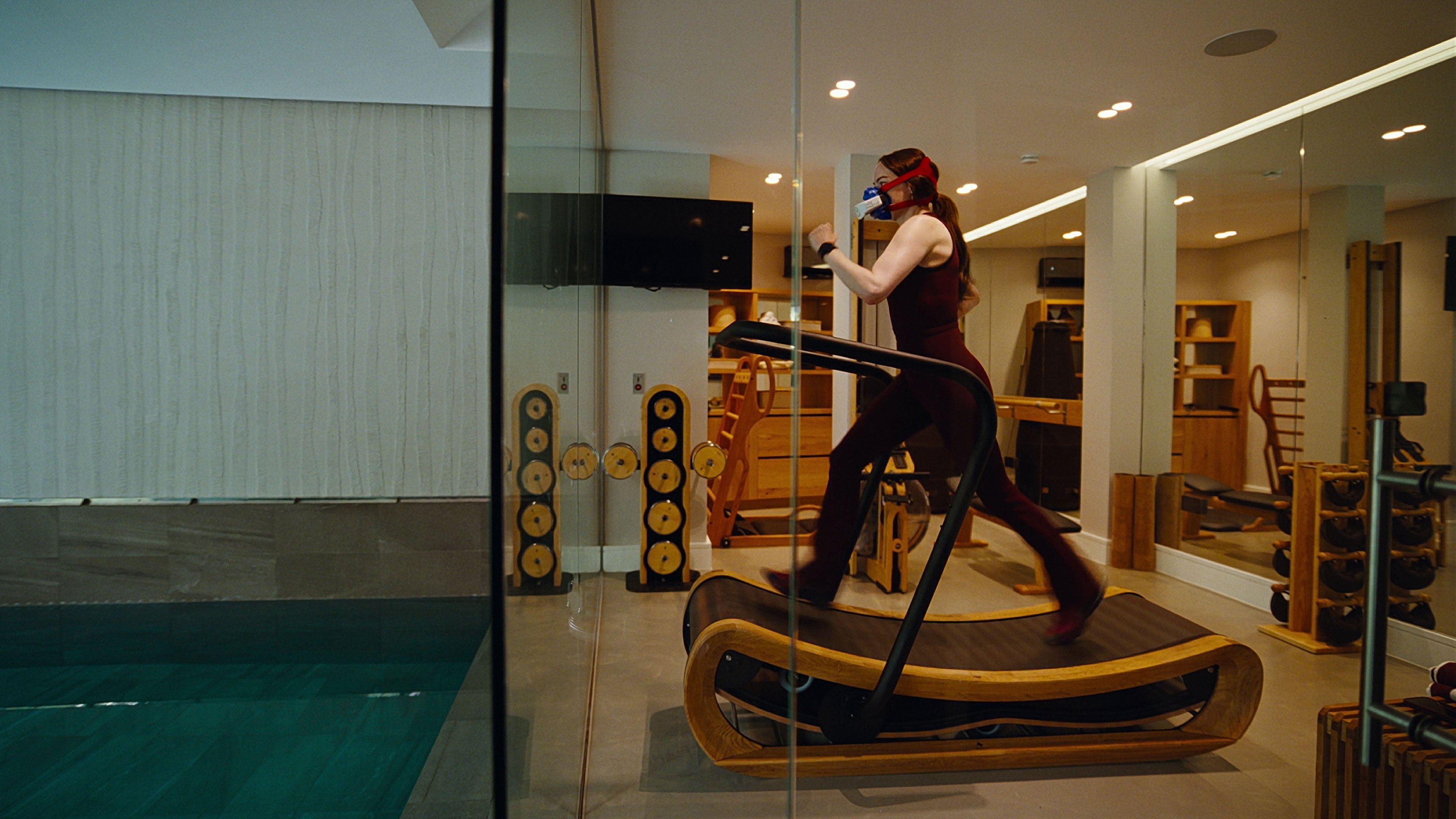 Caption: a woman is running on a treadmill in a gym