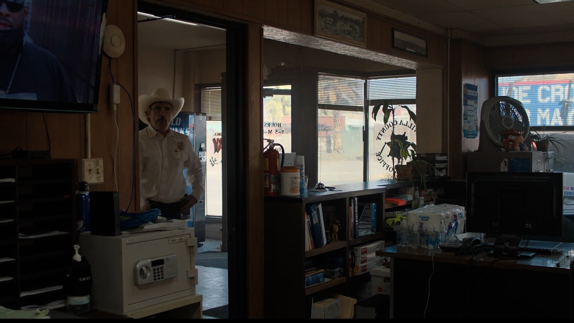 Caption: a man in a cowboy hat standing in a room