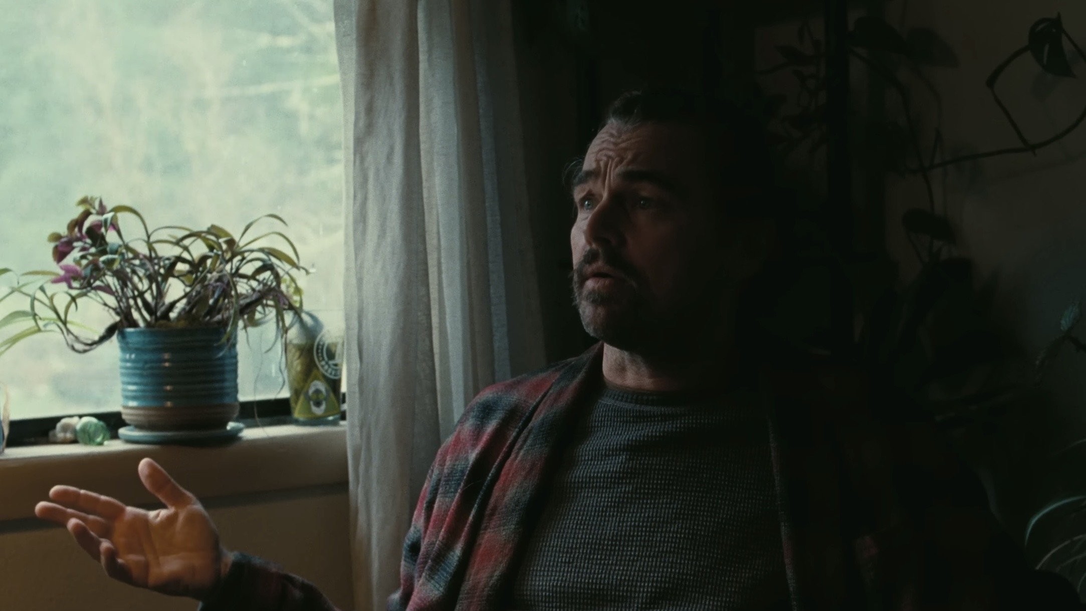 Caption: a man sitting in a chair in front of a window