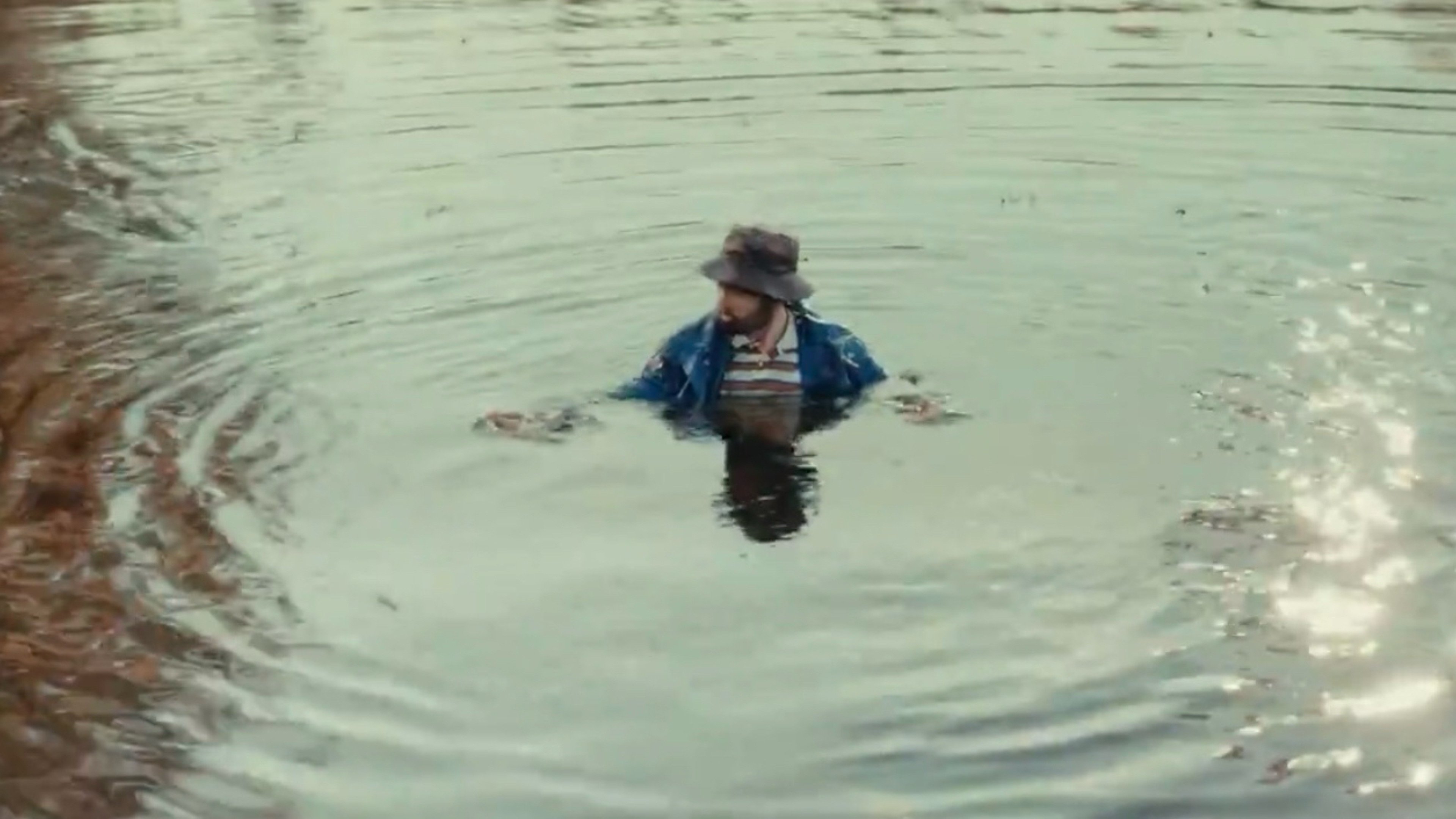 Caption: a person in a body of water with a hat on