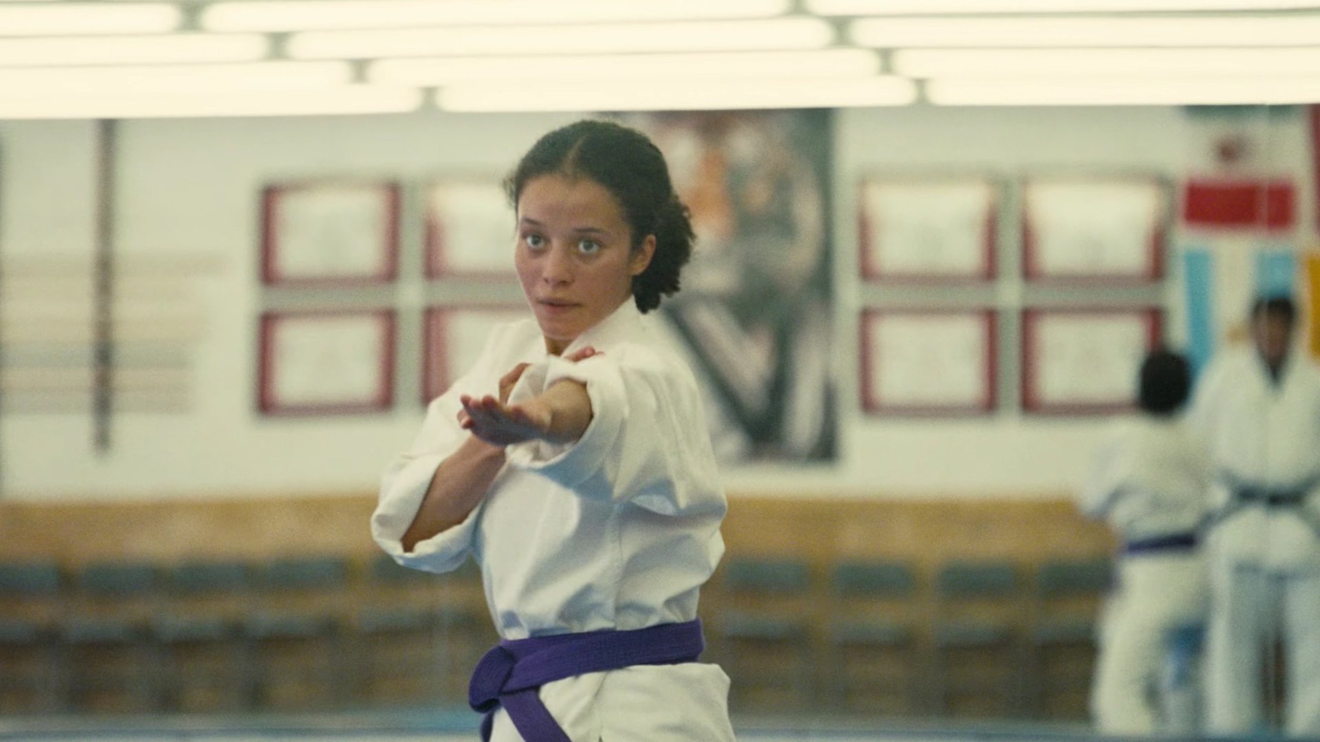 Caption: a woman is practicing karate in a gym