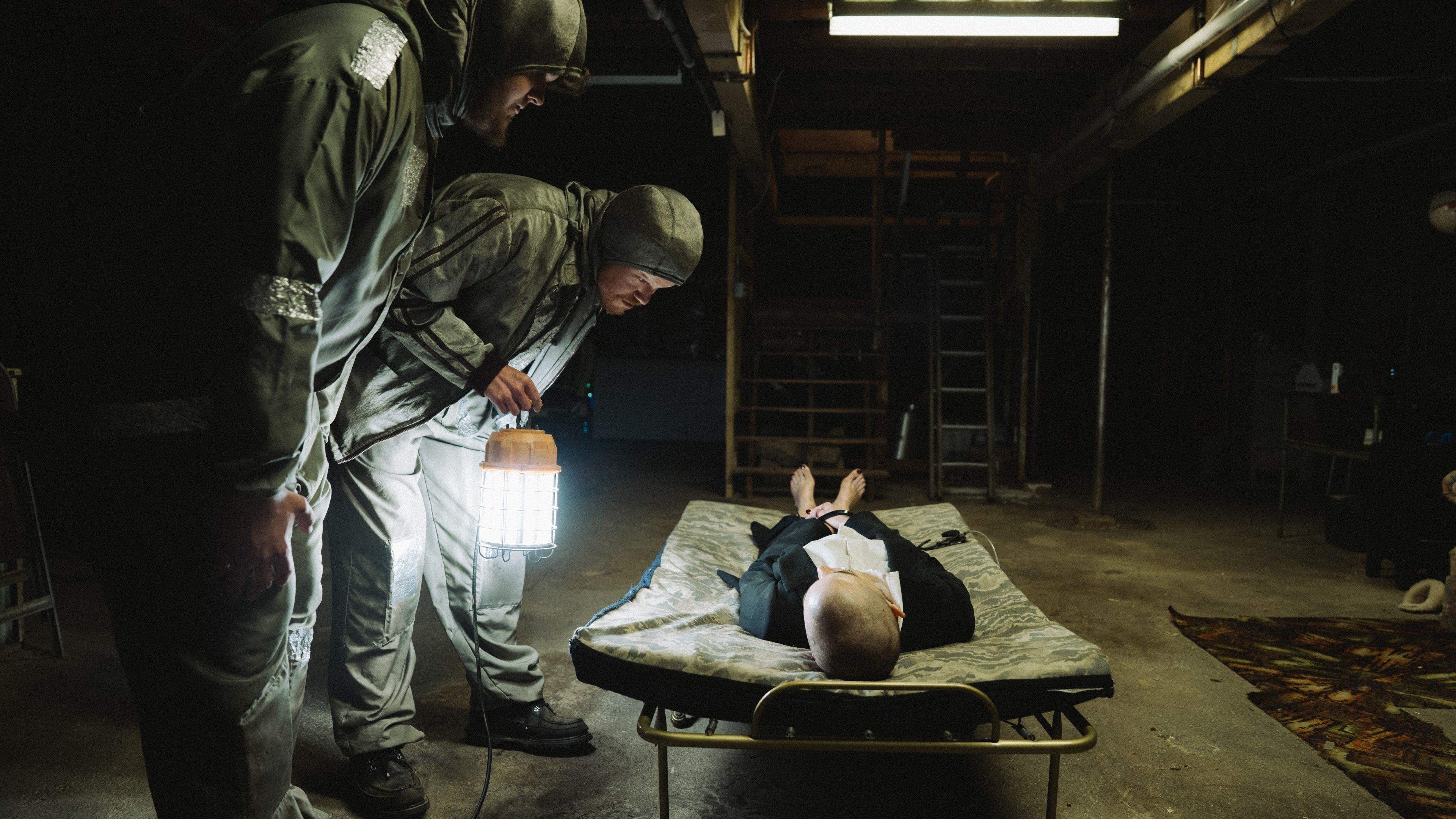 Caption: a man laying on a bed in a dark room