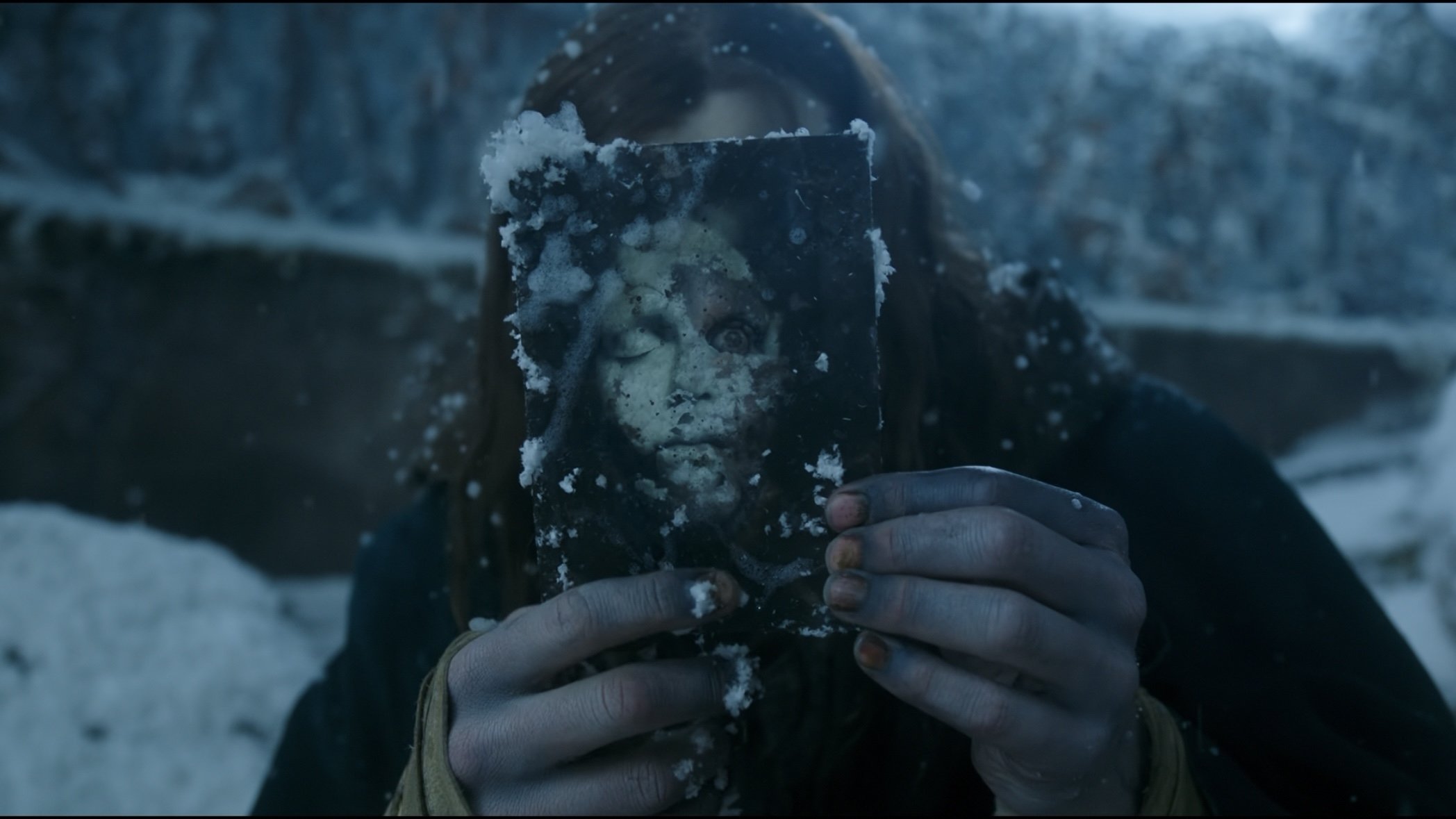 Caption: a woman holding up a piece of food covered in snow