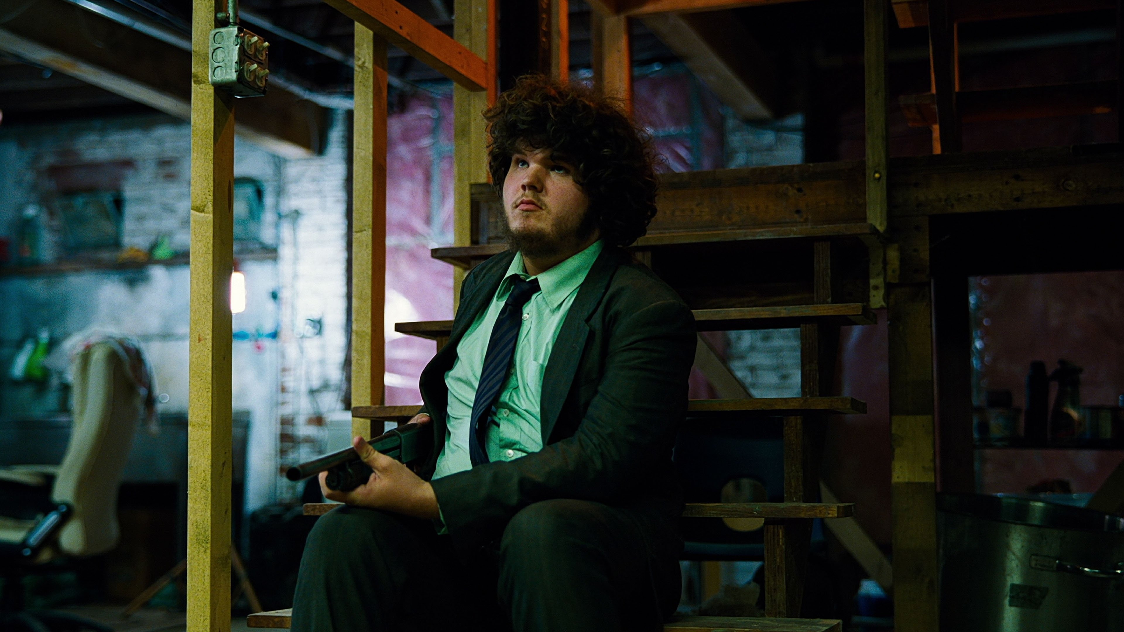 Caption: a man in a suit and tie sitting on a chair