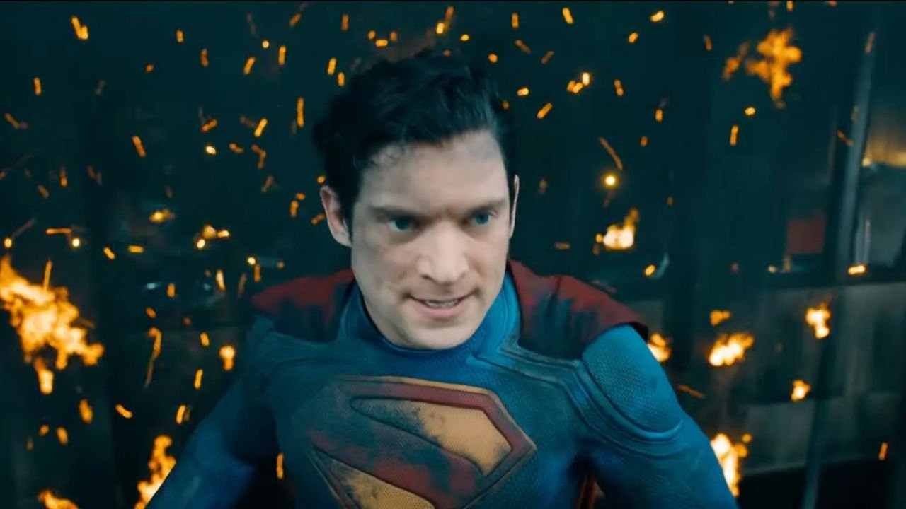Caption: a man in a superman costume standing in front of fire