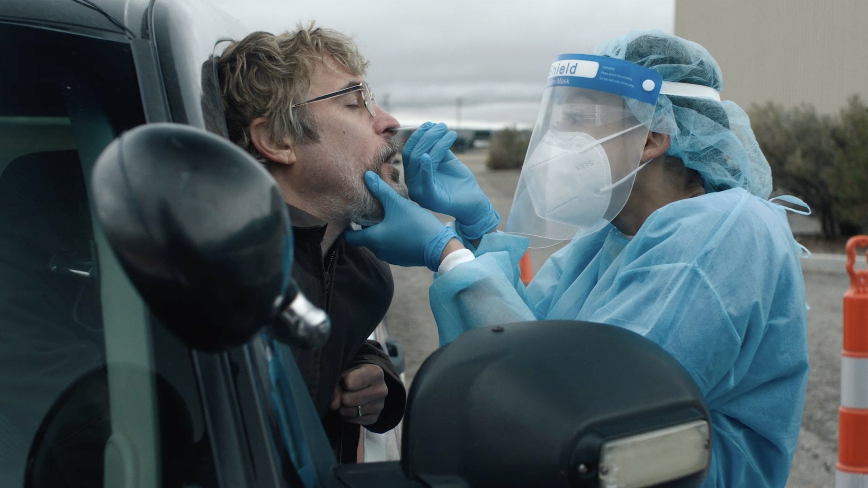 Caption: a man in a protective suit is talking on a cell phone