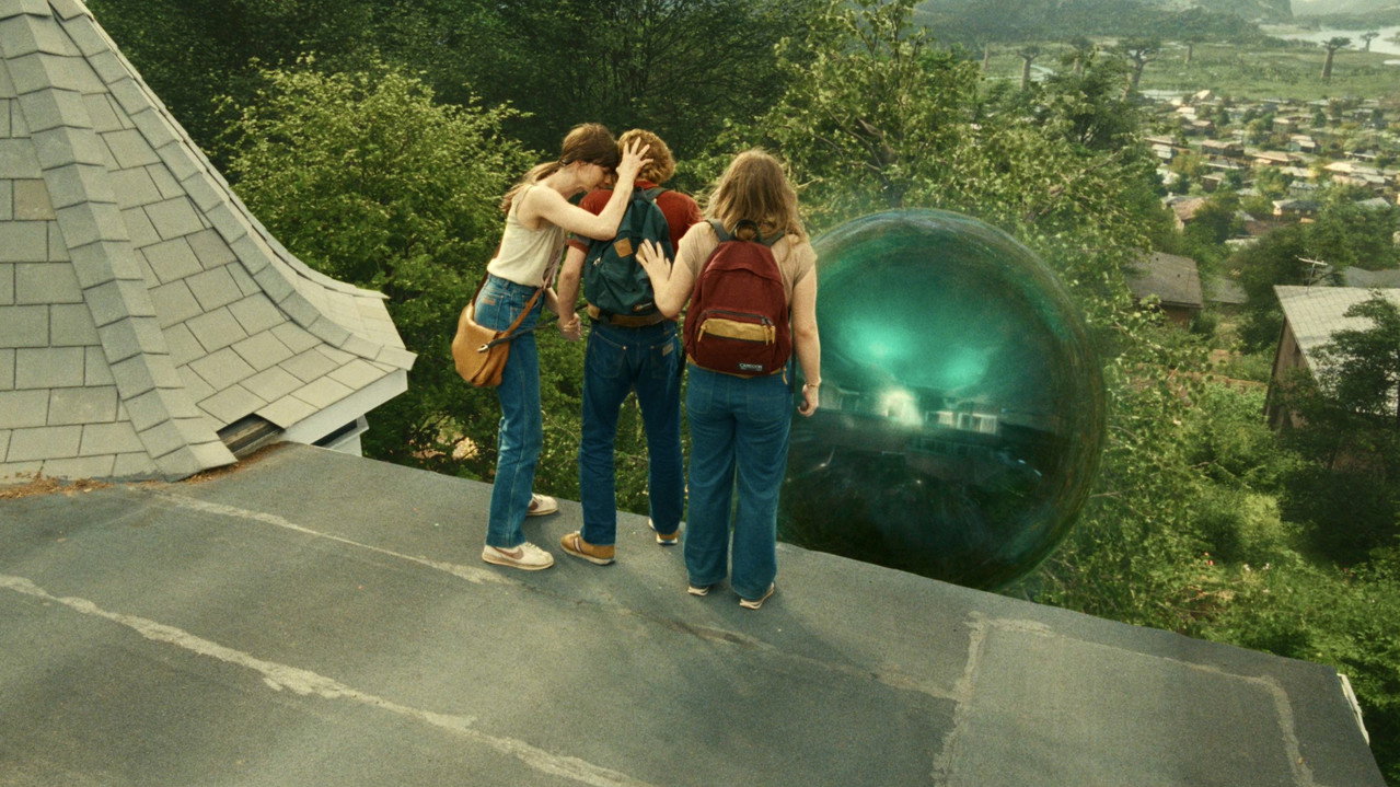 La Fin d'Oak Street (2026) - Denise et les enfants sur le toit face au trou de ver lumineux