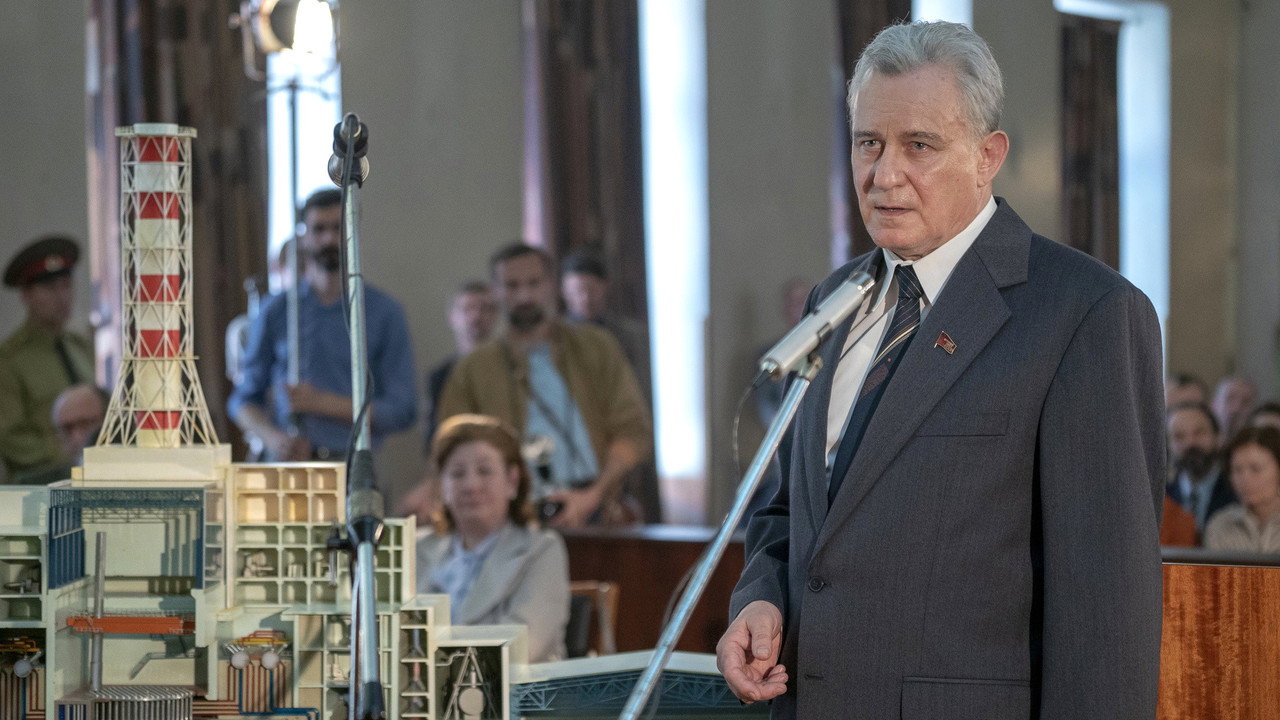 A man speaking beside a cutaway reactor model, Chernobyl (2019)