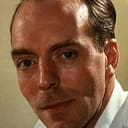 Simon Cadell als British News Reporter (uncredited)
