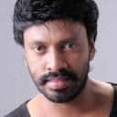 Harikumar als One among group dancers in a song “Naan Autokaaran”