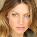 Jes Macallan als American Newscaster #2