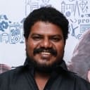 Aadukalam Murugadoss als Kathirvelan's friend
