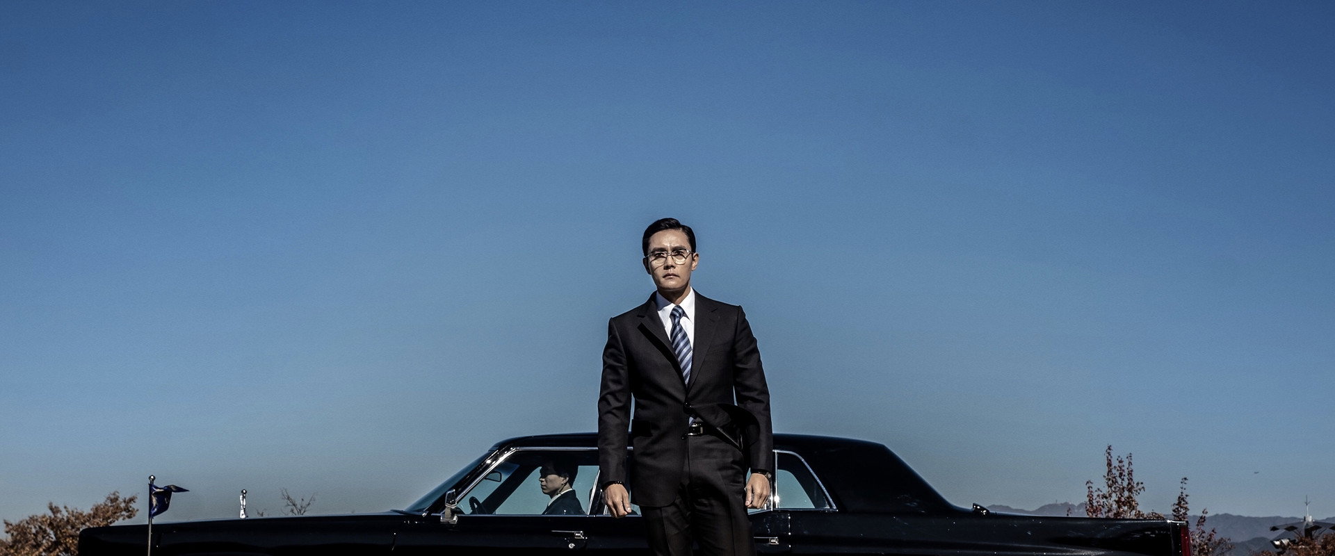 The Man Standing Next backdrop