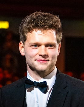 Sam Santrock as The Officiant