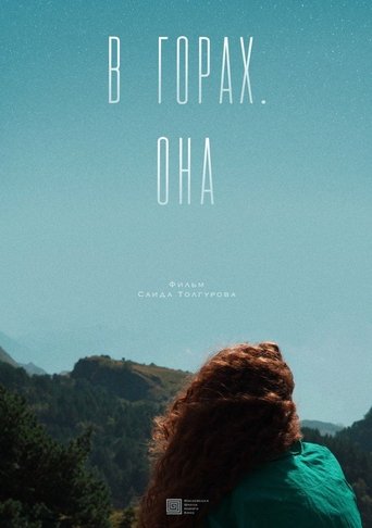 В горах. Она