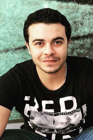 Taha Khalifa as Erios 2 in The Day They Killed Singing